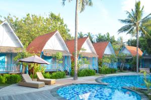珀尼达岛The MG Villa & SPA的一个带椅子和遮阳伞的游泳池的度假酒店