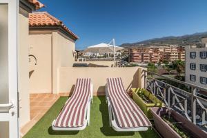 阿尔卡拉Callao Salvaje, apartamento a 200 mts de la Playa的设有一个配有两张躺椅的阳台,享有美景。