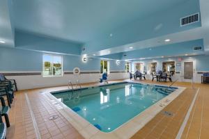伊利伊利烛木套房酒店的一个带桌椅的房间的大型游泳池