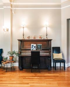 阿什维尔Princess Anne Boutique Hotel & Breakfast的客厅里的钢琴和两把椅子