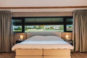 MaaslandWellness Bed & Breakfast by Leef的一间卧室设有一张大床和一个大窗户