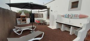 维拉韦德Villa Elisa的庭院配有遮阳伞和桌椅。