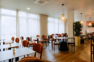 多特蒙德Moods Hotel Dortmund的用餐室设有桌椅和窗户。