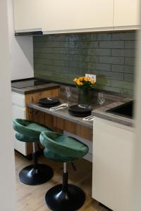 萨图马雷Hotel Vila Discret的厨房配有带两个绿色吧台凳的吧台