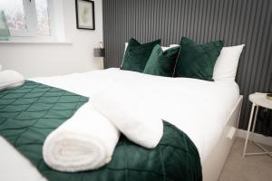 伍尔弗汉普顿Grand Station Suite的一张配有绿色和白色床单及枕头的大床