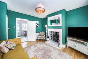 Boston SpaSt Mary's Cottage的客厅设有绿色的墙壁、电视和壁炉
