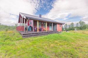 Trivelig hytte i Senja.的草山顶上一座红色的小房子