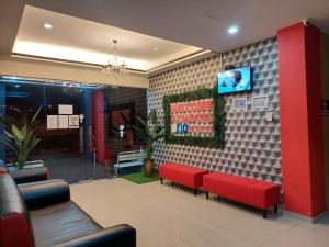 瓜拉江沙Pz Hotel的一间设有红色长椅和电视的等候室