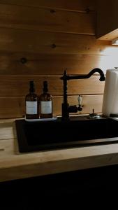 索蒂纳科奇Sylvan Valley Lodge and Cellars的浴室水槽上放两瓶威士忌