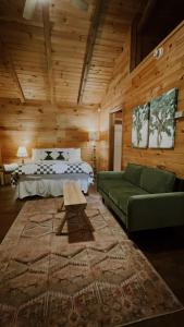 索蒂纳科奇Sylvan Valley Lodge and Cellars的客厅配有绿色沙发和床。