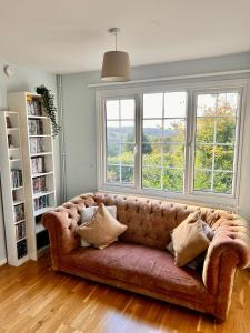 巴斯Spacious home in Bath, nature and city!的客厅设有一张沙发,配有两个窗户