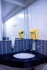 曼谷Visiting Card Hotel & Resort的一间带水槽和镜子的浴室