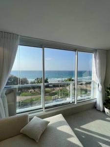 巴特亚姆Vacation Apartment By The Beach的客厅设有海景大窗户