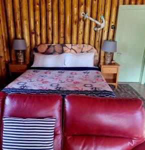 沃瓦High Falls Motel & Cabins的一张位于带红色皮沙发的房间的床铺