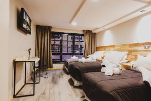 圣卡洛斯-德巴里洛切Hotel Eco Max的酒店客房设有三张床和窗户。