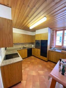 波斯基亚沃Casa Lalla affittasi nel centro di Poschiavo的一个带木制橱柜和桌子的大厨房