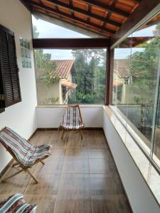 米格尔-佩雷拉Hostel Ares do Mundo的客房设有带椅子和窗户的阳台。