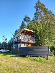 布丘普雷奥Preciosa mini-casa-bote bien ubicada y linda vista的坐落在郁郁葱葱的绿色田野上的房子