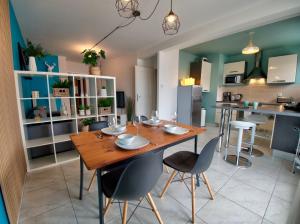 梅斯☆ L'Exotique ☆ 2 chambres ☆ NETFLIX ☆的一间带木桌和椅子的用餐室