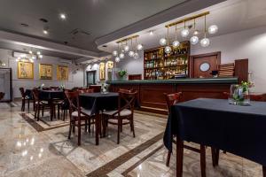 拉多姆Hotel Poniatowski的一间带桌椅的餐厅和一间酒吧
