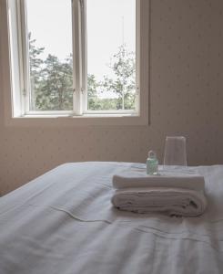 特克斯福什Turistgården Töcksfors的一张带毛巾的白色床,设有窗户