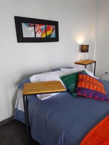 乔阿奇Casablanca Choachi的一间卧室配有一张木桌和一张床铺。