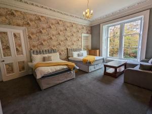 BonnybridgeBonnyside House的一间带两张床和一张沙发的卧室