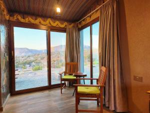 Dār SawdāʼJebel Shams Resort منتجع جبل شمس的客房设有桌椅和大窗户。