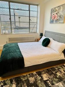 伦敦Beautiful Quality Apartment in Camden Town的一间卧室配有一张带绿毯的大床