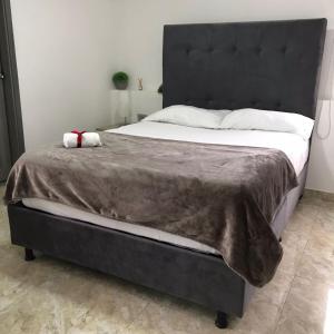 MaicaoHotel El Peniel的一张大床,配有黑色床头板和白色床单