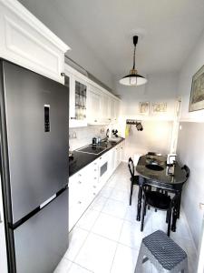 沃洛斯Sophie's Guest House的厨房配有桌子和不锈钢冰箱。