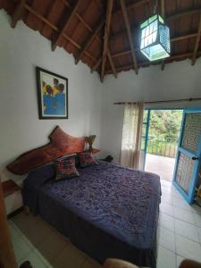 萨赛马Finca Jardín del Agua的一间带床的卧室,位于带窗户的房间内