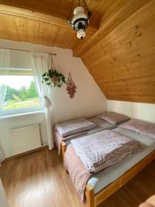 Zubrzyca GórnaAgroturystyka Pod Modrzewiem的配有木天花板的客房内的两张床