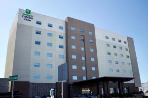 提华纳Holiday Inn Express & Suites - Tijuana Otay, an IHG Hotel的一座酒店大楼,前面有标志