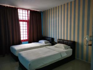 科塔达曼萨拉Parc Hotel Pelangi Damansara的配有窗户的酒店客房内的两张床