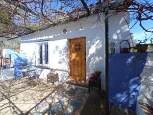 伊格拉德拉谢拉El Charcón的一间白色的小房子,设有木门