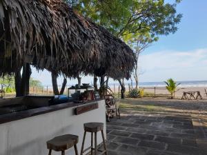 波波约Popoyo Surfcamp的一个带凳子的酒吧,享有海滩美景