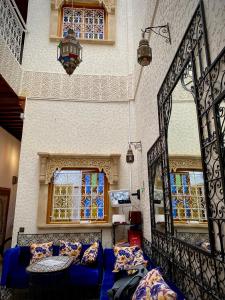 拉巴特Riad Najiba的客厅设有蓝色的沙发和窗户。