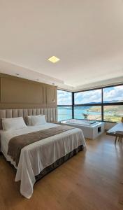 卡皮托利乌Vista do Lago Hotel的一间卧室设有一张大床和大窗户