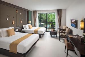奥南海滩Centara Anda Dhevi Resort and Spa - SHA Plus的酒店客房配有两张床和一张书桌