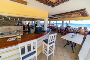 喀巴里特WOW location Kite Beach Oceanfront Panoramic Views 2 DECKS 2 Bedrooms的酒吧位于餐厅内,以海洋为背景