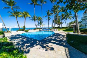 喀巴里特WOW location Kite Beach Oceanfront Panoramic Views 2 DECKS 2 Bedrooms的一座棕榈树和海洋游泳池
