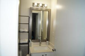 萨里Ground Level One Bedroom Suite的一间带水槽和大镜子的浴室