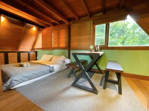 龙目岛库塔Comfortable Wood House second floor and attic的一间卧室配有一张床、一张书桌和一个窗户。