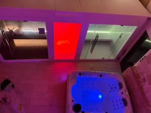 格拉维纳普利亚B&B Sul Ponte的浴室配有紫色和红色的灯光浴缸。