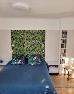 巴涅尔-德吕雄Bel Appartement Bagneres De Luchon Centre的一间卧室配有蓝色的床和花卉床头板
