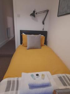 LincolnshireColville House的一间卧室配有一张黄色的床和灯