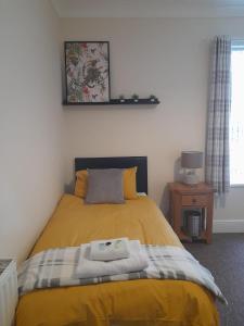 LincolnshireColville House的一间卧室配有一张黄色毯子床
