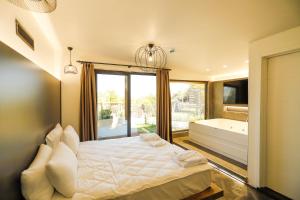萨潘贾World DREAMS Forest的卧室配有床、浴缸和窗户。