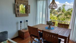康隆尼角Tropical Palms apartment Mauritius的一间带木桌和窗户的用餐室